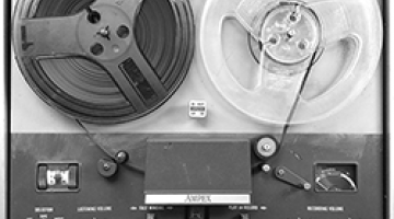 Image of anachronistic reel-to-reel tape player, shown in black & white